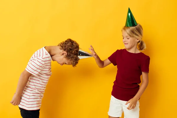 Imagen de diversión positiva de vacaciones de niño y niña con gorras en su cabeza fondo aislado —  Fotos de Stock