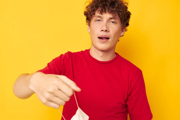 Junger gelockter Mann mit Schutzmasken, der isolierten Hintergrund unverändert posiert — Stockfoto