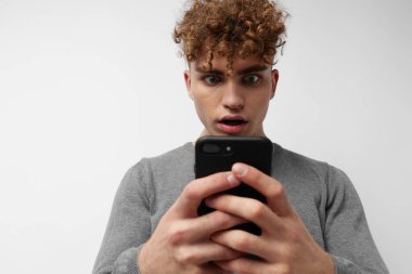 Telefonda konuşan çekici bir adam. Duygularını belli ediyor.