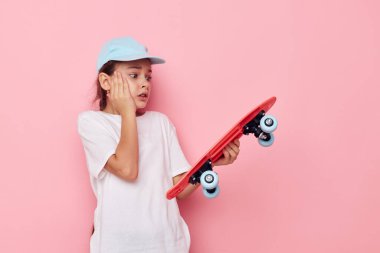 Beyaz tişörtlü şirin kız şapkası. Kaykaylı. Yaşam tarzı değişmemiş.