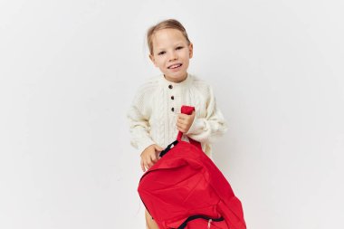 Güzel, genç bir kız okul çantası ve kafasında şapkası var.