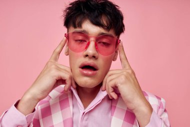 Yakışıklı adam pembe gözlüklü, kareli ceket modasında. Yaşam tarzını değiştirmemiş.