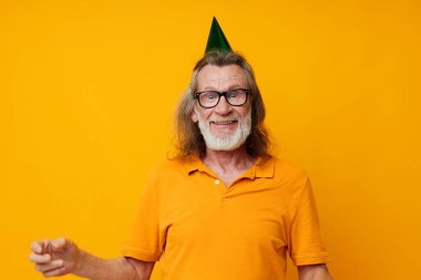 Yaşlı gri saçlı adam kafasında eğlenceli bir doğum günü şapkası izole edilmiş bir arka plan