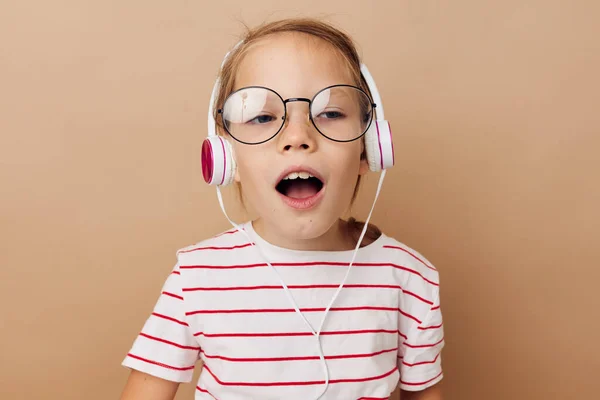 Neşeli küçük kız kulaklıkla müzik dinliyor çocukluk eğlencesi — Stok fotoğraf