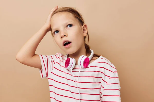 Bella giovane ragazza a strisce t-shirt cuffie gesto mani infanzia inalterato — Foto Stock