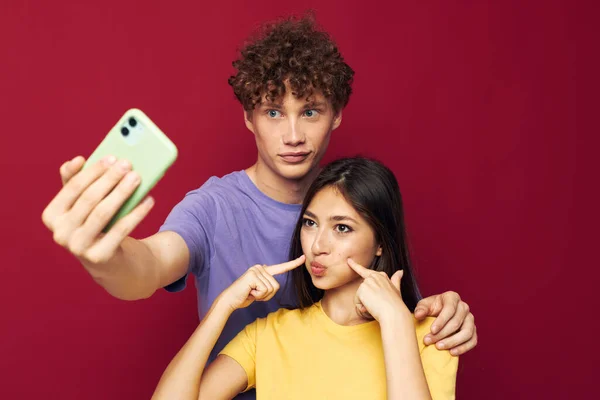 Uomo e donna stile moderno emozioni divertimento telefono rosso sfondo — Foto Stock