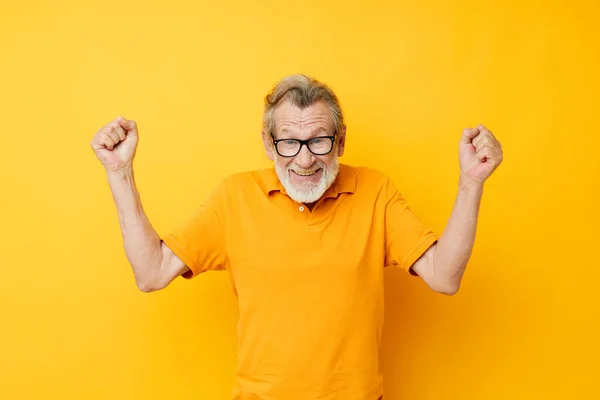 Portrait of happy senior man posing yellow tshirt glasses cropped view — Stock fotografie