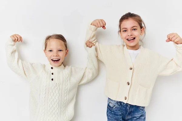 Dos niñas en suéteres posando fondo de luz de la infancia — Foto de Stock