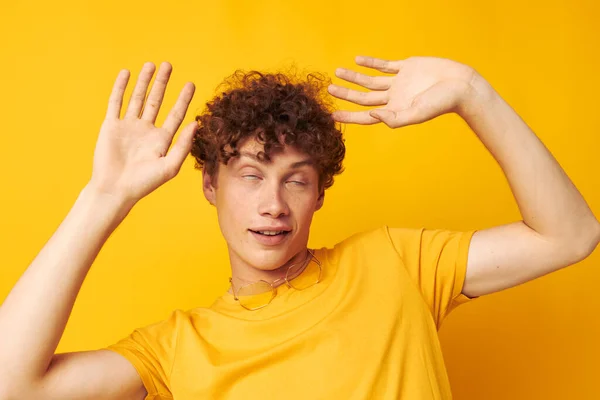 Genç, kıvırcık bir adamın portresi Gençlik tarzı gözlük stüdyosu gündelik sarı arka planı değiştirilmemiş — Stok fotoğraf