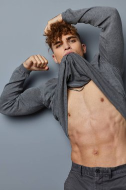 Gri kazaklı çekici bir adam. Moda stüdyosu izole edilmiş.