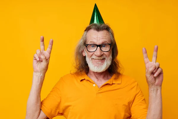 Senior grey-haired man fun birthday cap on the head isolated background — стоковое фото