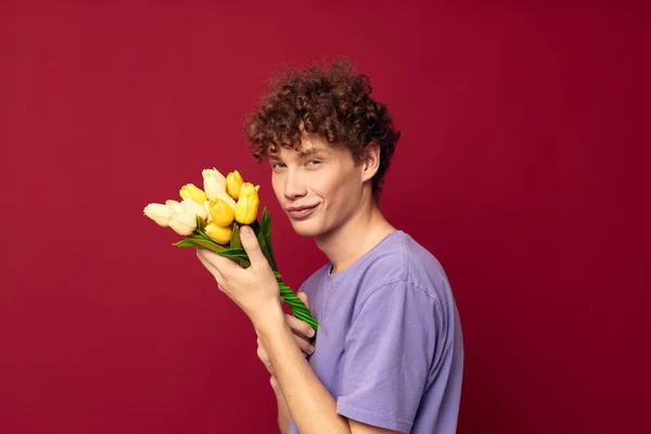 Teenager holding a yellow bouquet of flowers purple t-shirts isolated background unaltered — 图库照片