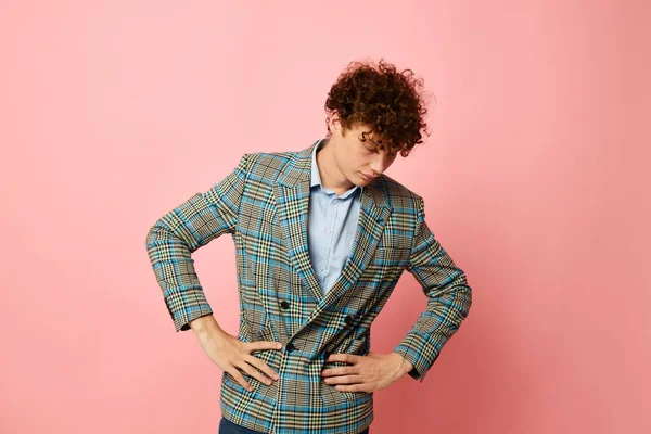 Portrait of a young curly man checkered blazer elegant style posing fashion pink background unaltered — Stock fotografie