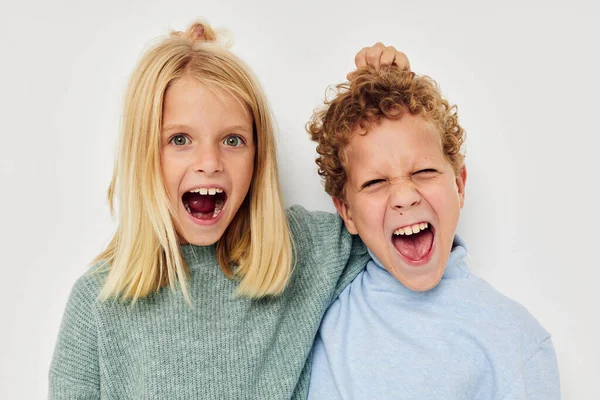 Симпатичные стильные дети в разноцветных свитерах позируют для веселого светлого фона — стоковое фото