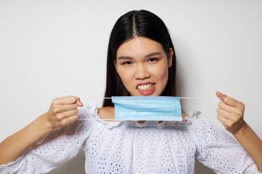 Asyalı görünümlü bir kadın tıbbi maske koruması var. Geçmişi değiştirilmemiş.