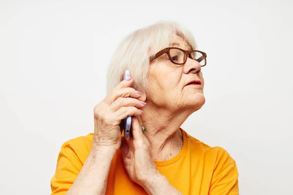 Фото пожилой женщины в модных очках со смартфоном в руке эмоции крупным планом — стоковое фото