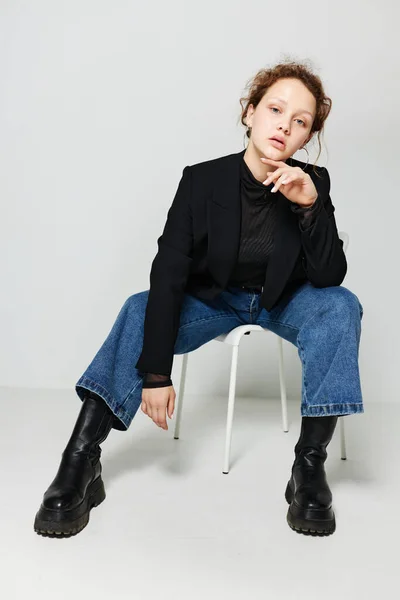 Vacker kvinna sitter på en stol i en svart jacka mode poserar Livsstil oförändrad — Stockfoto