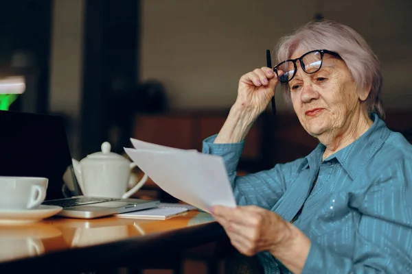 Hermosa anciana madura sentada en un café con una taza de café y un portátil Estilo de vida inalterado — Foto de Stock