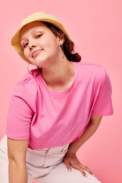Νεαρή γυναίκα μόδα ρούχα καπέλο ροζ t-shirt διακόσμηση με ροζ φόντο — Φωτογραφία Αρχείου