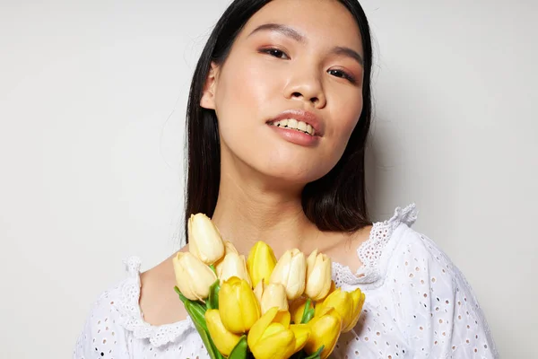Жінка з азіатським зовнішнім романтичним букетом квітів поруч зі студією облич незмінною — стокове фото
