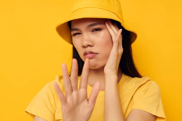 Morena bonita usando um chapéu amarelo posando emoções amarelo fundo inalterado — Fotografia de Stock
