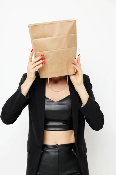 Beautiful woman in a leather suit black jacket with a bag on his head isolated background — 图库照片