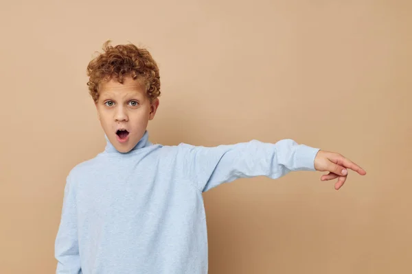Menino encaracolado em uma camisola azul posando diversão infância inalterada — Fotografia de Stock