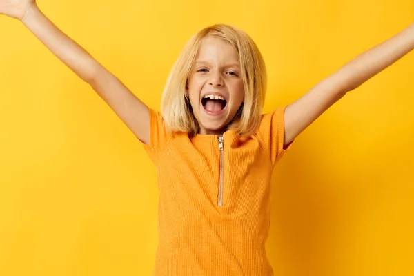 Bonito menina em um amarelo t-shirt sorriso posando estúdio cor fundo inalterado — Fotografia de Stock