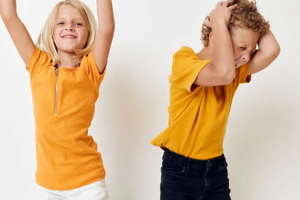 Menino bonito e menina em camisetas amarelas estúdio de entretenimento infantil — Fotografia de Stock