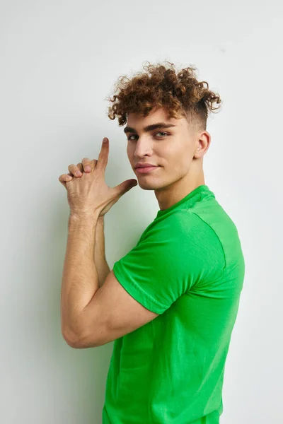 Kinky Kerl in grünen T-Shirts Emotionen posiert isoliert Hintergrund — Stockfoto