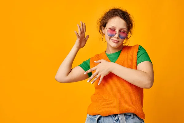 Mooi meisje oranje sweatshirts zonnebril veelkleurig bril aanbod bijgesneden uitzicht ongewijzigd — Stockfoto