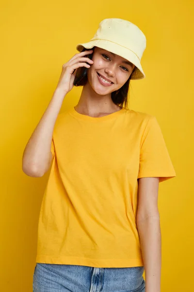 Attraktiv kvinna i en gul hatt Ungdom stil avslappnad prata på telefonen isolerad bakgrund — Stockfoto