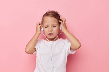 Kulaklık takan beyaz tişörtlü tatlı bir kız. Yaşam tarzı değişmemiş.