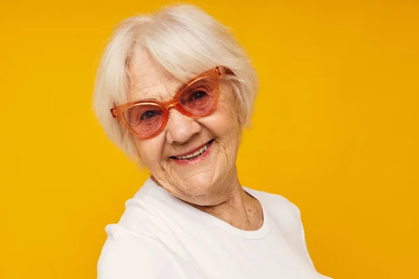 Sonriente anciana problemas de visión con gafas de fondo amarillo — Foto de Stock