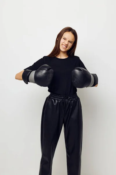 Young beautiful woman in boxing gloves punch in black pants and a T-shirt Lifestyle unaltered — Stockfoto
