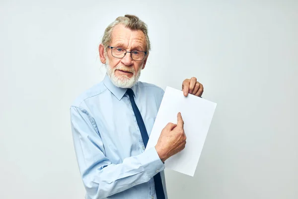 Старший седой мужчина с документами на бумажном фоне — стоковое фото