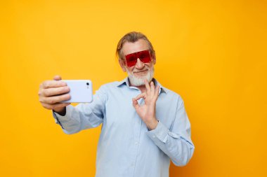 Telefon izole edilmiş, kırmızı gözlüklü, yaşlı, kır saçlı adam.