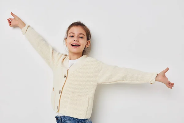 Маленькая девочка позирует в белом свитере светлом фоне — стоковое фото