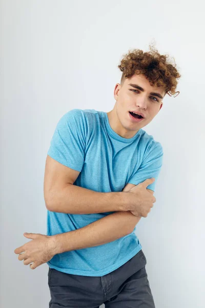 Handsome man with curly hair in a blue t-shirt — Stock Photo, Image