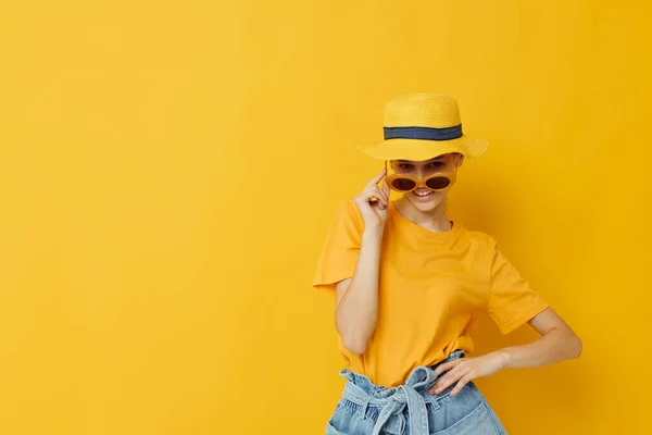 Moda jovem mulher em amarelo t-shirt posando moda no panamá fundo amarelo — Fotografia de Stock