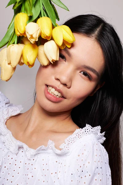 Portrét asijské krásné mladé ženy romantika kytice květin v blízkosti obličeje světlo na pozadí beze změny — Stock fotografie