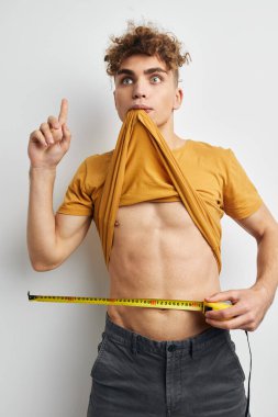 guy with curly hair measuring tape posing