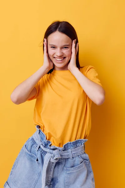 Gyönyörű lány egy sárga póló érzelmek nyári stílus sárga háttér — Stock Fotó