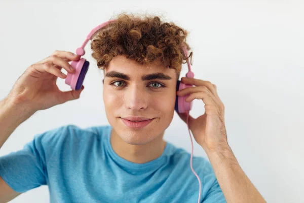 Kinky guy in blue t-shirts pink headphones fashion light background — Stock Photo, Image
