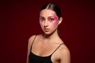 Genç, güzel bir kadın lüks kozmetik ürünleri sergileyen el kol hareketleri yapıyor. Geçmişi değiştirilmemiş.