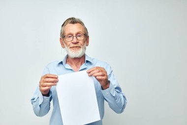 Emekli yaşlı bir adamın elinde bir sayfa fotokopi çekerek izole edilmiş arka plan oluşturduğu fotoğraf.