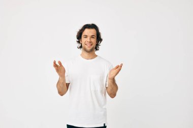Cheerful man in a white T-shirt communication by phone light background
