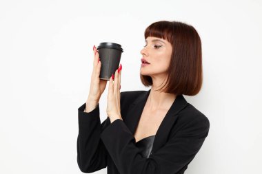 Siyah takım elbiseli güzel bir kadın içki cazibesi olan bir kupa izole edilmiş bir arka plan.