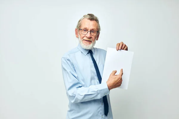 Старший седой мужчина с документами на бумажном фоне — стоковое фото