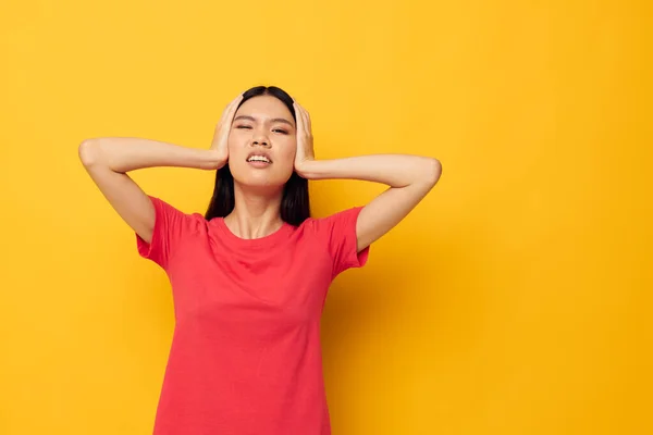 Femme avec l'apparence asiatique dans un t-shirt rouge posant émotions fun fond jaune inchangé — Photo